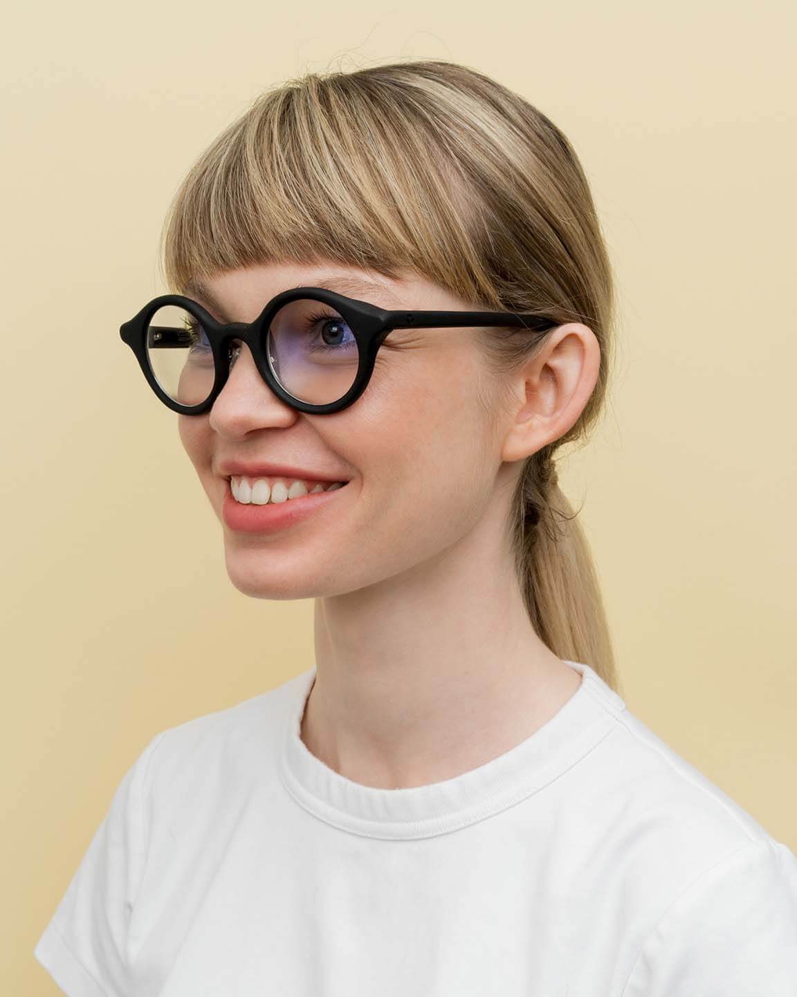 Laden Sie das Bild in den Galerie-Viewer, Smiling woman wearing black round coffee-based optical frames, perfect for sustainable everyday style.