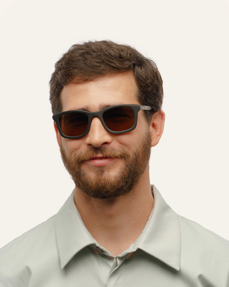 Dandy sunglasses with warm brown lenses on a white background, featuring a black coffee-based frame