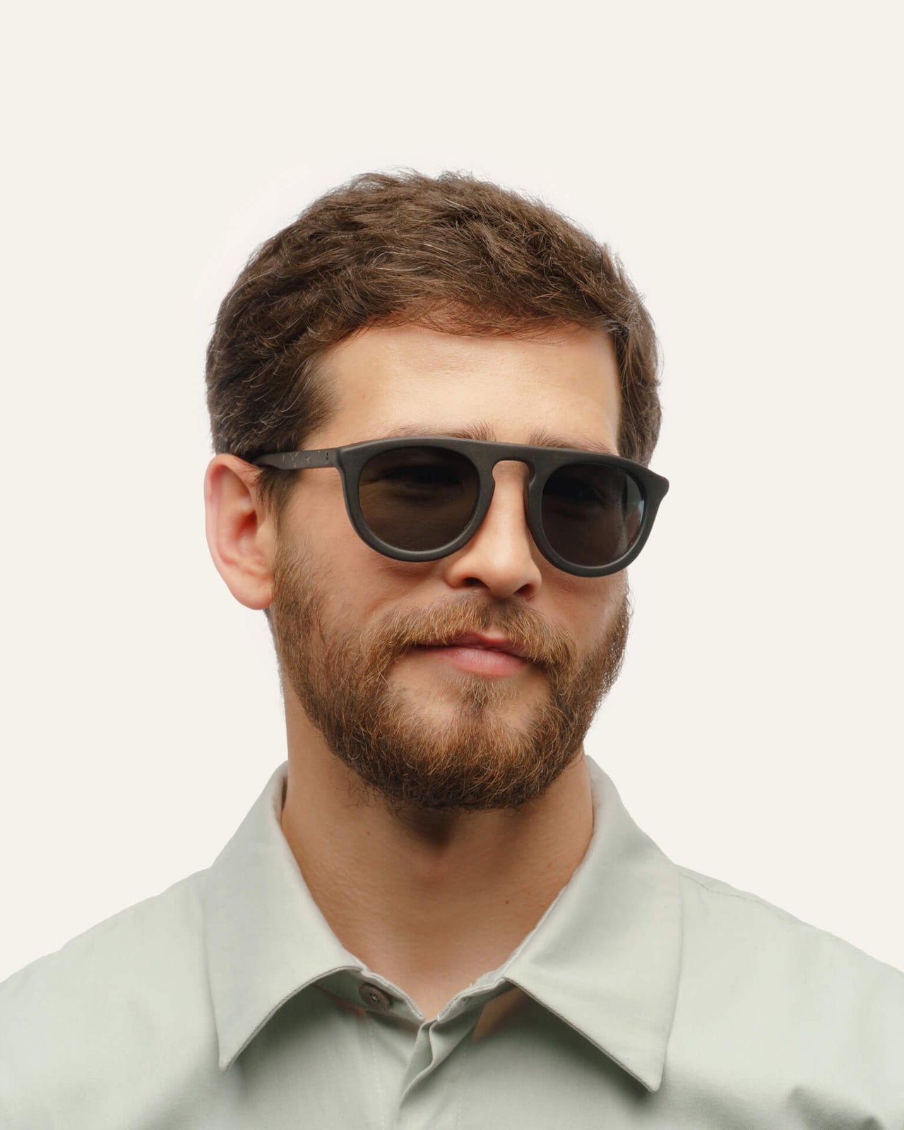 Laden Sie das Bild in den Galerie-Viewer, Man wearing modern coffee-based sunglasses, showcasing sustainable craftsmanship and durable flax accents.