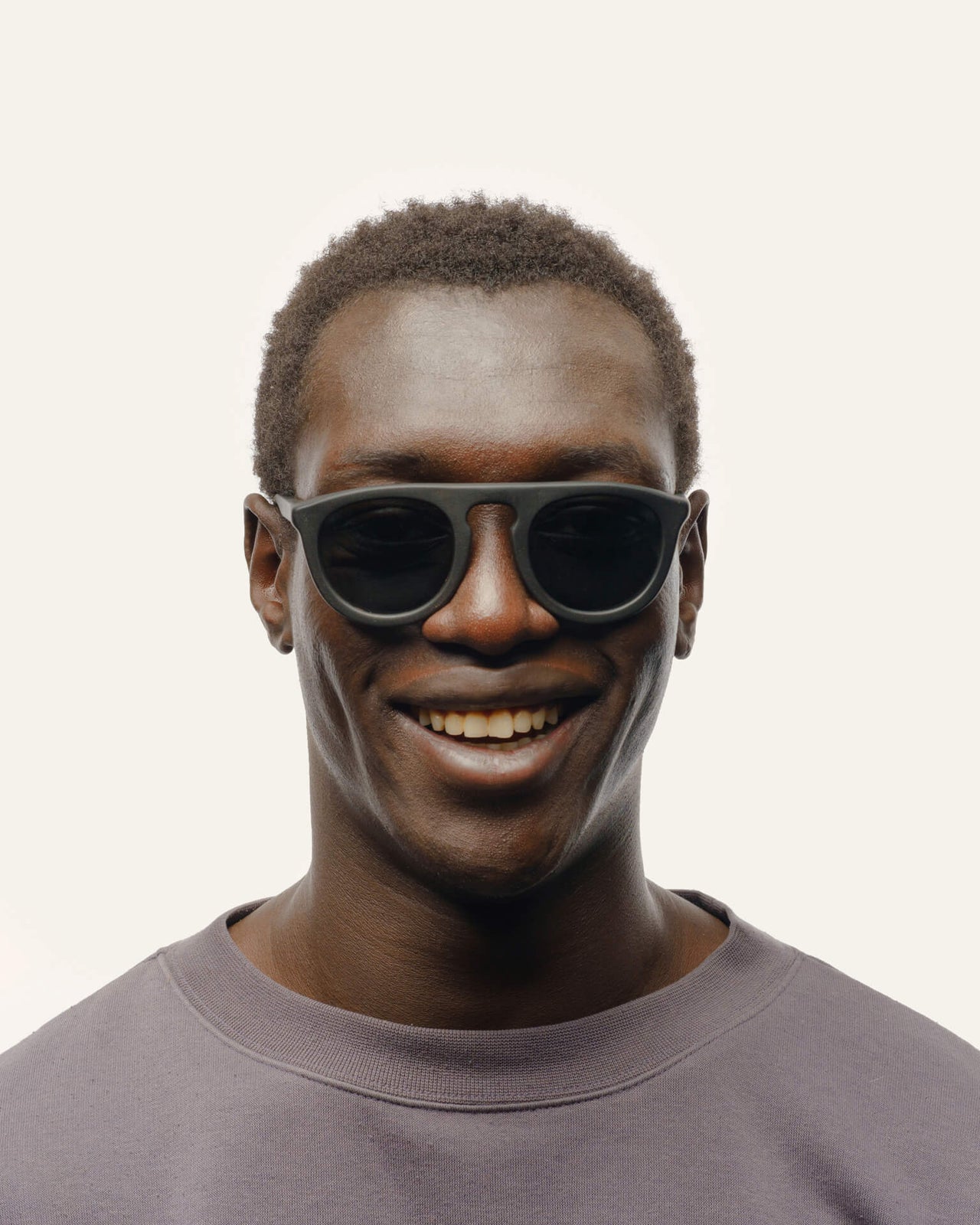 Laden Sie das Bild in den Galerie-Viewer, Smiling man wearing sustainable coffee-based sunglasses with gray lenses, ideal for urban professionals in California.