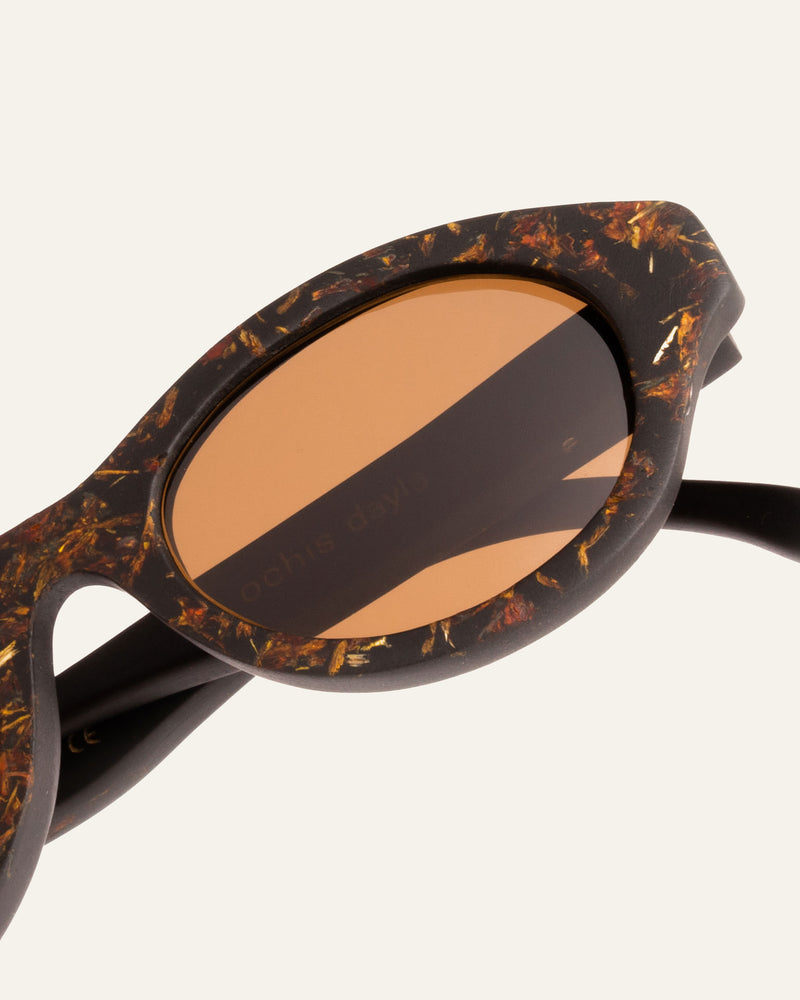 Biobased sunglasses with brown polarized lenses, featuring coffee-based frames accented with marigold petals