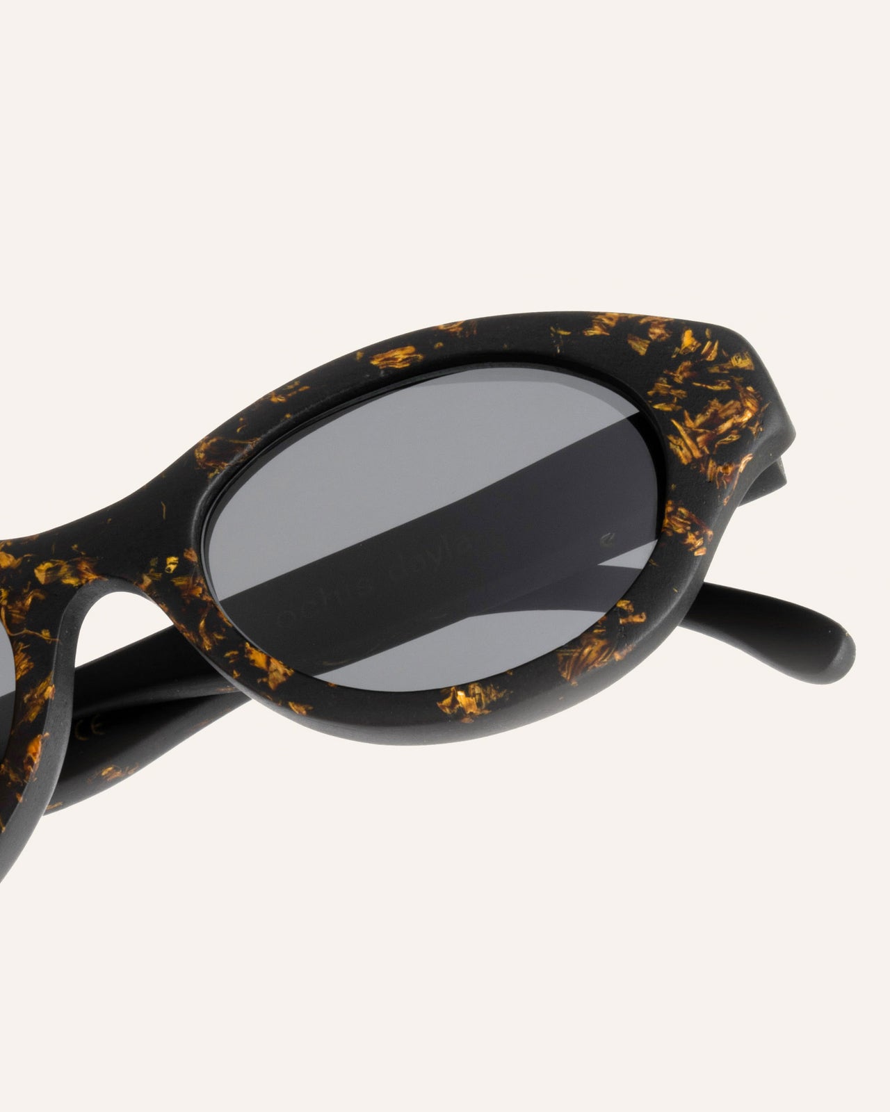 Laden Sie das Bild in den Galerie-Viewer, Close-up of sustainable sunglasses, highlighting intricate sunflower petal details on the coffee-based frame