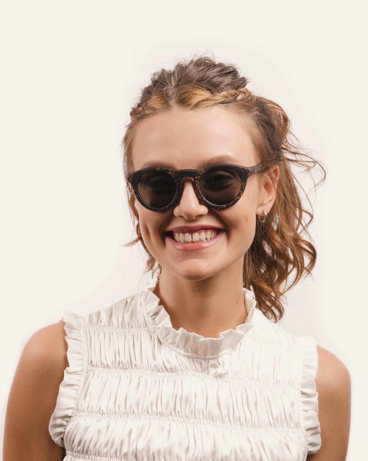 Laden Sie das Bild in den Galerie-Viewer, Woman wearing Kole Volya sunglasses, showcasing the eco-friendly design with gray UV-protective lenses and sunflower petal details