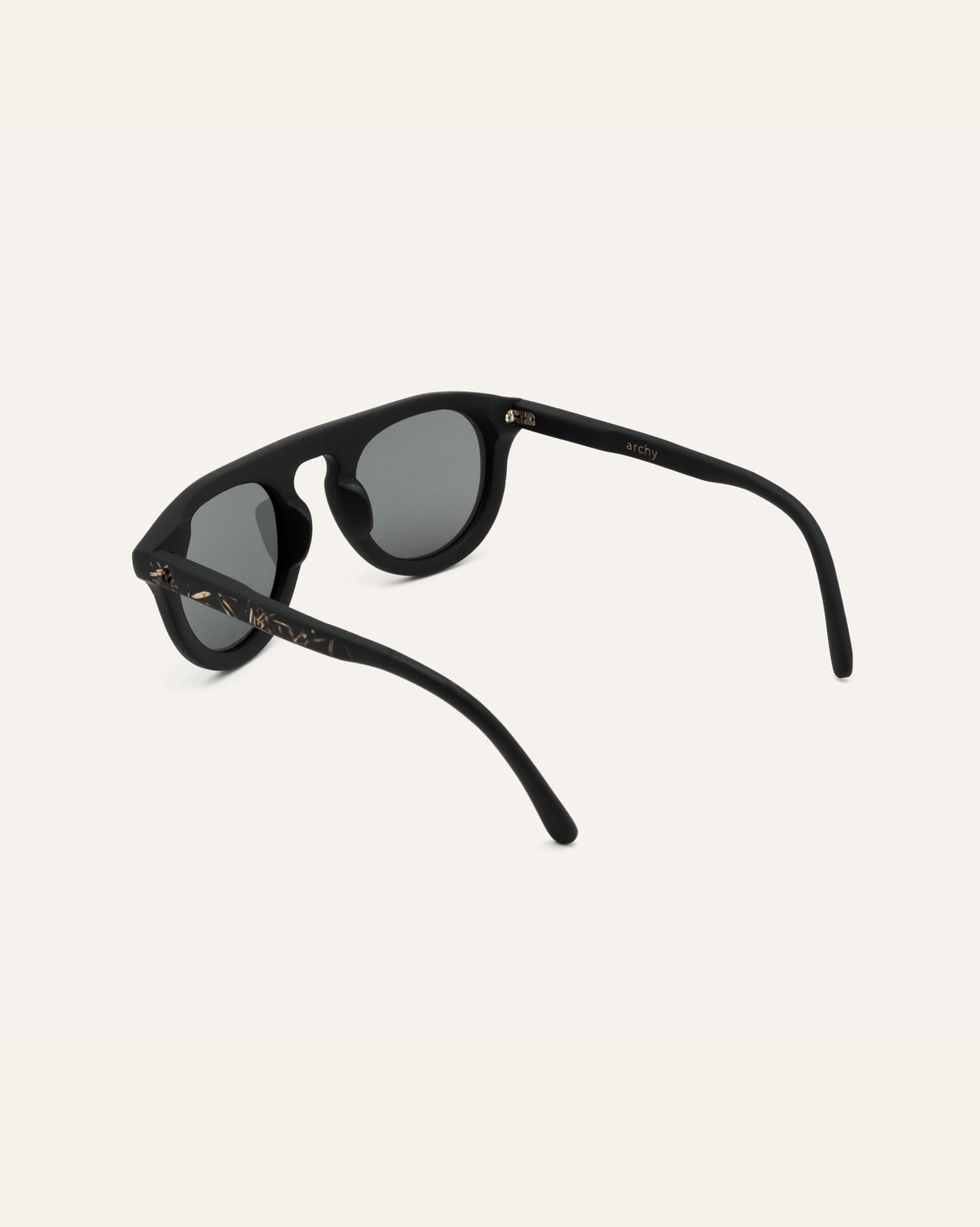 Laden Sie das Bild in den Galerie-Viewer, Close-up of black sunglasses with gray lenses, highlighting flax-covered temples and minimalist design.