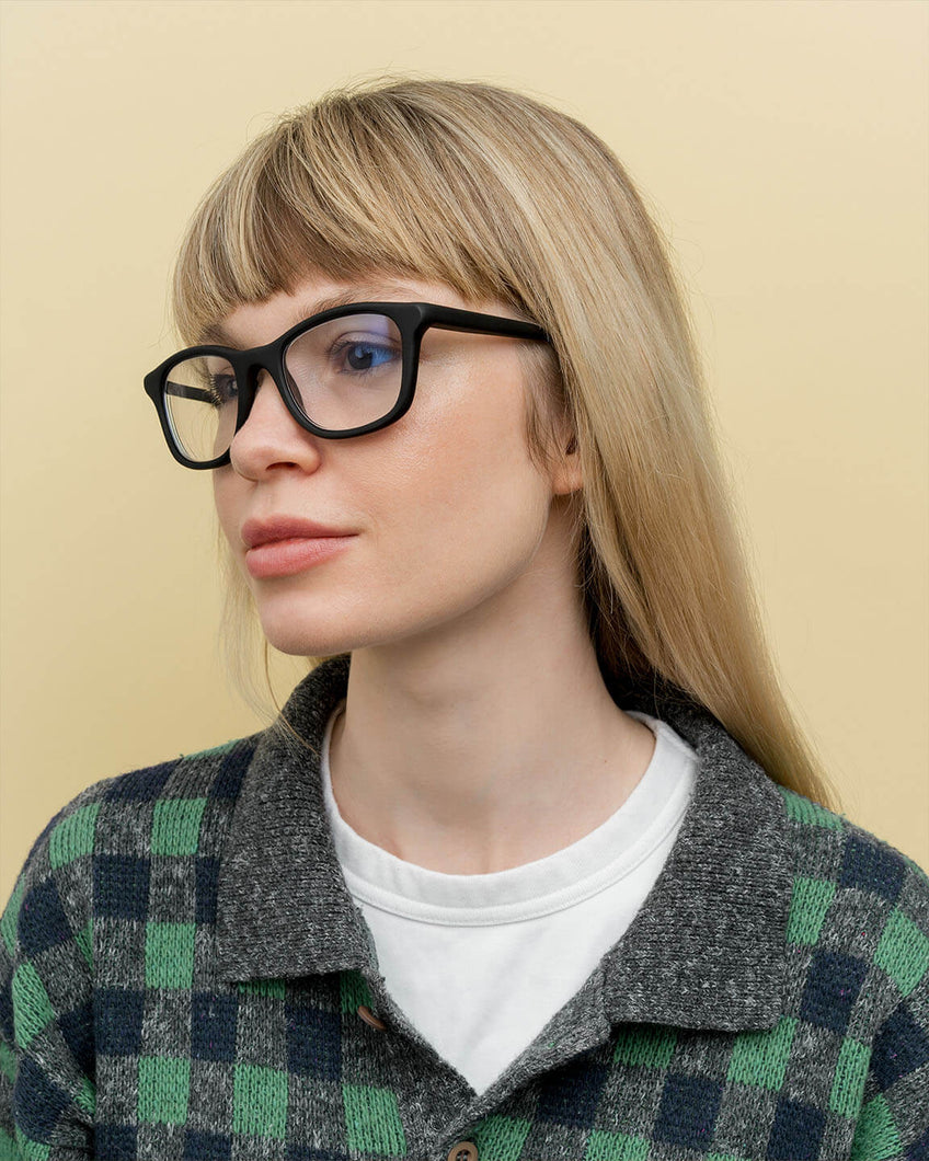 Blonde woman wearing minimalist black prescription glasses, perfect for eco-conscious professionals in London.