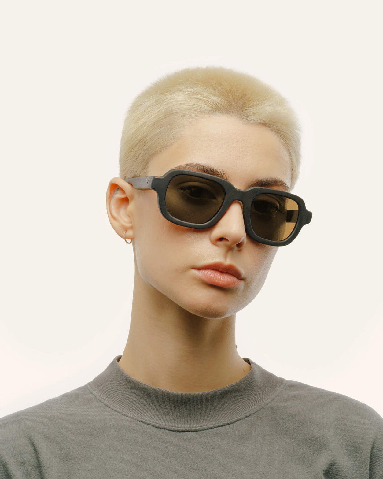 Load image into Gallery viewer, Woman wearing sunglasses with brown lenses, bold, sustainable design.
