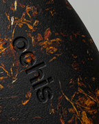 Close-up of the Ochis logo on a coffee-based case enriched with marigold petals, emphasizing handcrafted sustainability