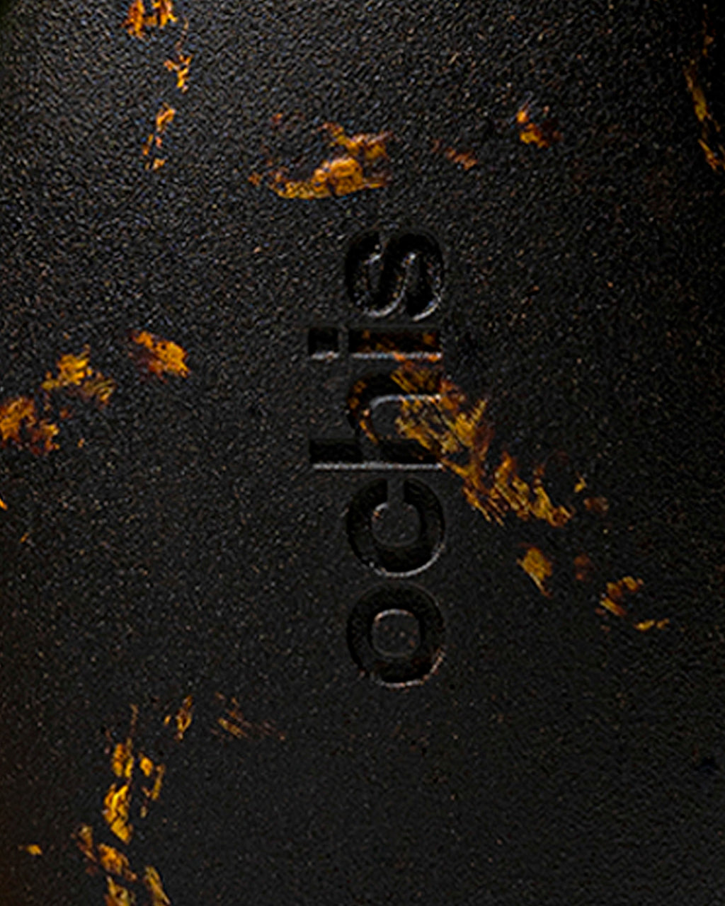 Ochis logo embossed on a black case adorned with sunflower petals, emphasizing its eco-conscious craftsmanship