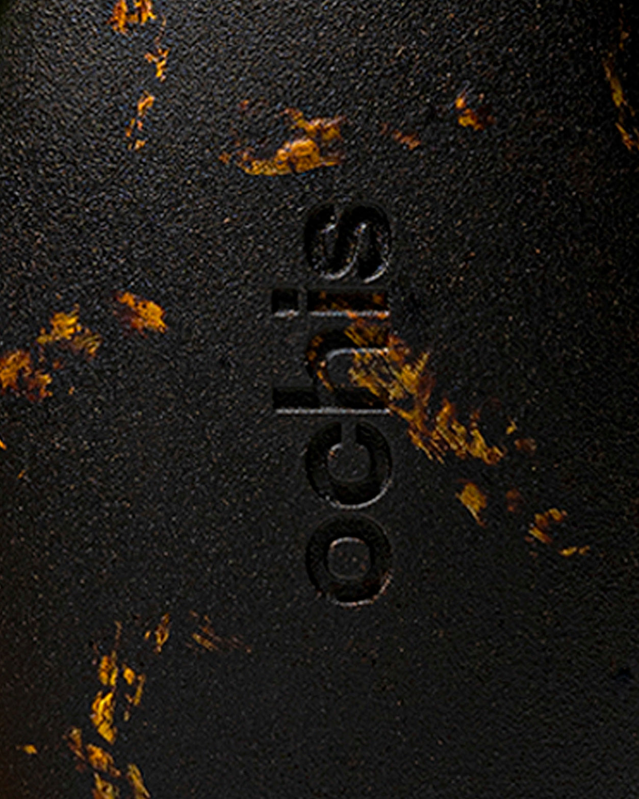 Ochis logo embossed on a black case adorned with sunflower petals, emphasizing its eco-conscious craftsmanship