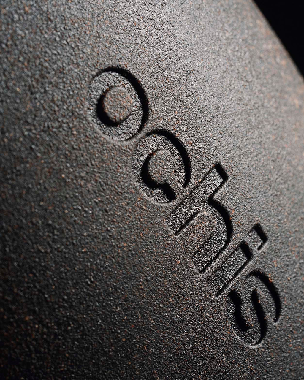 Close-up of the black coffee-based eyewear case, featuring a detailed view of the Ochis logo embossed on the surface