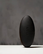 Black coffee-based glasses case standing vertically, highlighting its unique, nature-inspired shape and durable construction