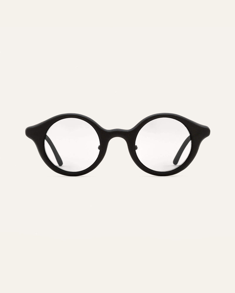 Smiling woman wearing black round coffee-based optical frames, perfect for sustainable everyday style.