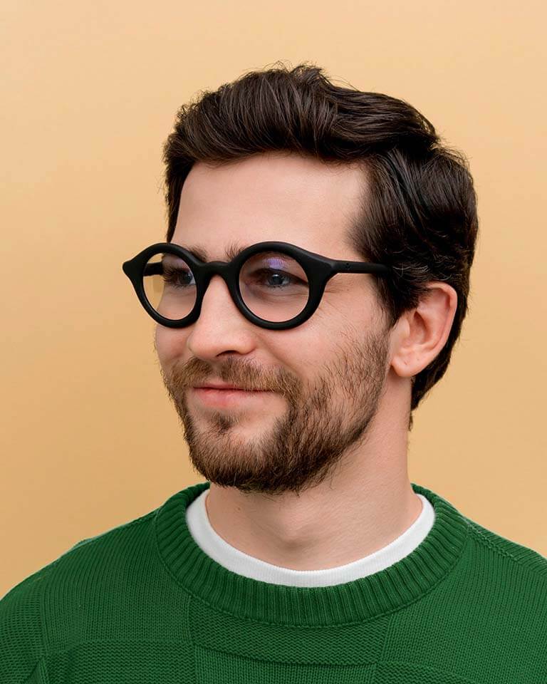 Load image into Gallery viewer, Man wearing black round prescription frames crafted from coffee, combining comfort and eco-friendly craftsmanship
