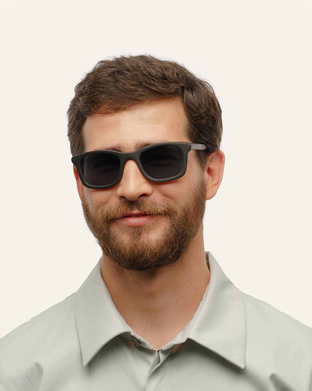 Man wearing eco-friendly coffee sunglasses with gray sun protective lenses