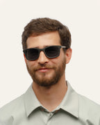Man wearing eco-friendly coffee sunglasses with gray sun protective lenses