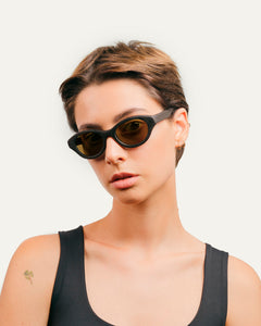 Woman wearing sustainable sunglasses with flax-covered details and warm brown lenses for a natural, stylish look