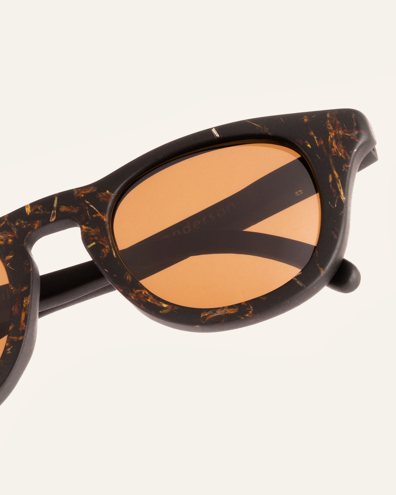 Load image into Gallery viewer, Close-up of sustainable sunglasses, showcasing intricate marigold petal detailing and earthy brown lenses.
