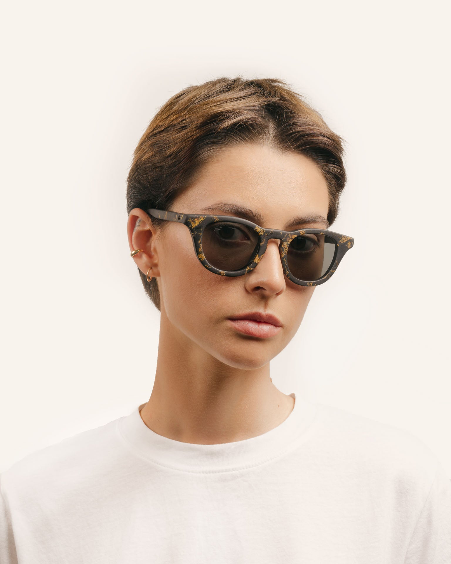 Woman wearing bold eco-friendly sunglasses, showcasing sunflower-inspired details and sleek gray lenses