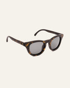 Side view of modern sunglasses with gray lenses, blending natural materials with minimalist design.