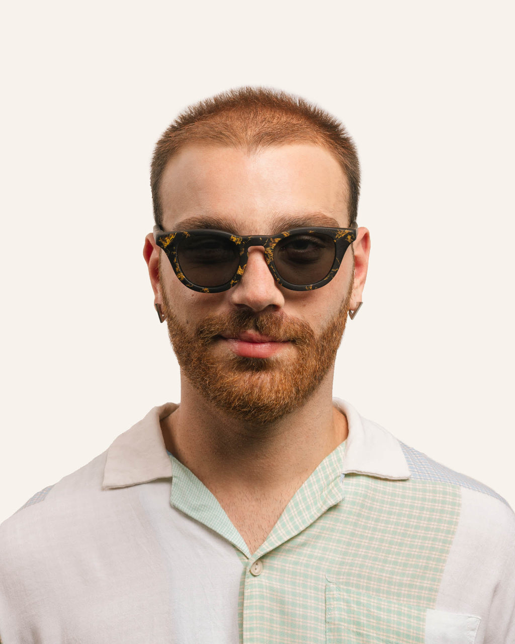Man in unisex sunglasses, highlighting sustainable craftsmanship and sunflower petal accents.