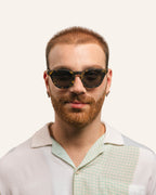 Man in unisex sunglasses, highlighting sustainable craftsmanship and sunflower petal accents.