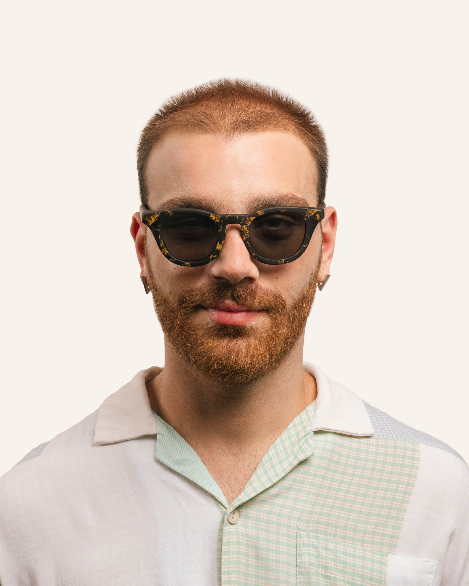 Man in unisex sunglasses, highlighting sustainable craftsmanship and sunflower petal accents.
