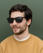 Man wearing lightweight coffee-based sunglasses with sleek gray lenses, perfect for minimalists in Germany.