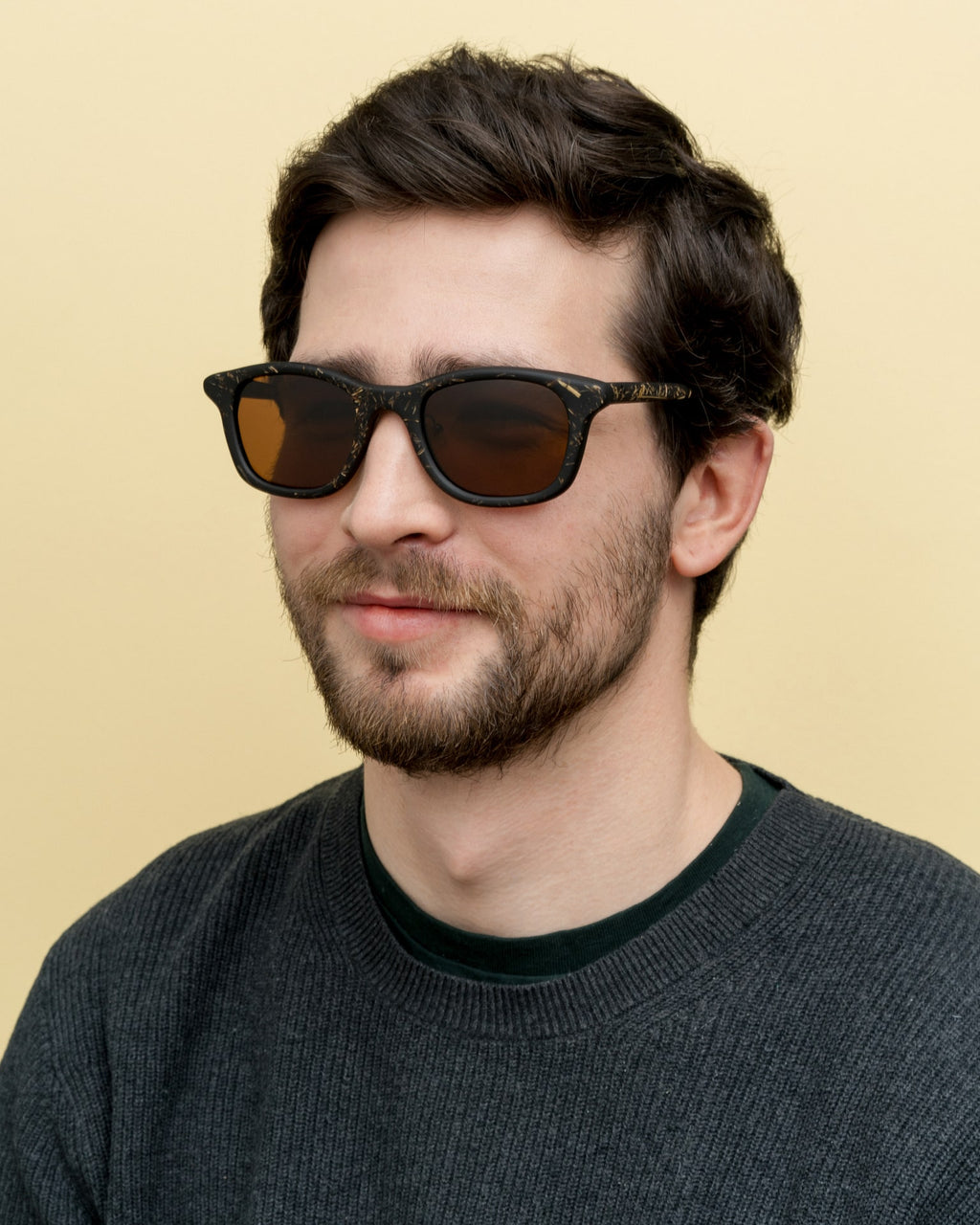 Man wearing sustainable black sunglasses with warm brown lenses, perfect for daily use in California.
