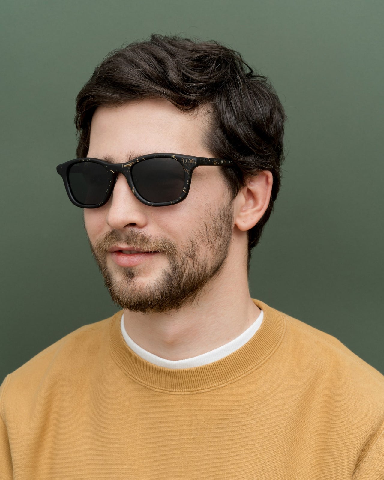 Load image into Gallery viewer, Man in modern black sunglasses with flax-covered details, perfect for eco-conscious individuals.
