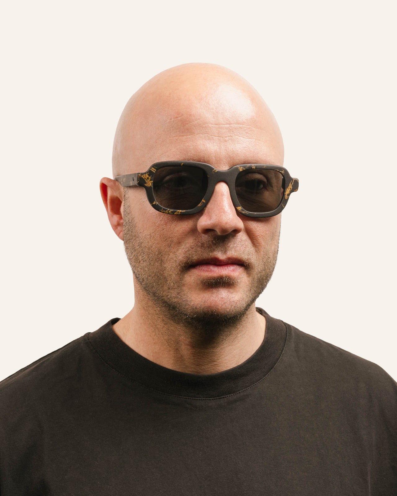 Load image into Gallery viewer, Man wearing sustainable sunglasses with flower accents and a bold, modern design
