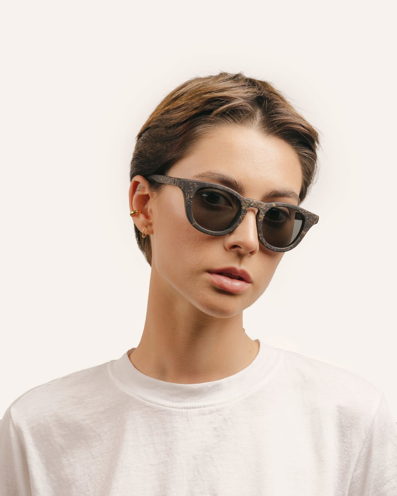 Load image into Gallery viewer, Woman in eco-conscious sunglasses, showcasing their elegant design and sleek gray lenses.
