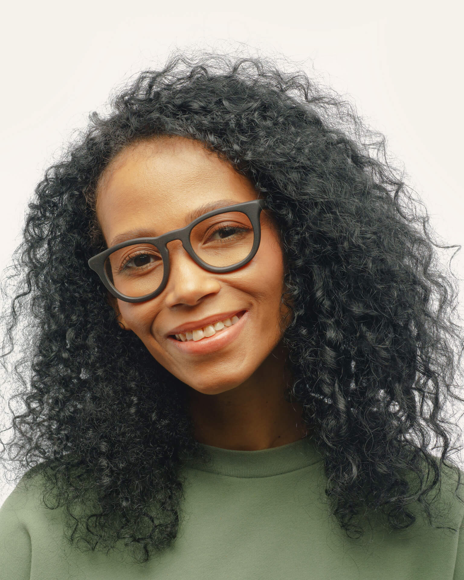 Woman with curly hair wearing Anderson Black optical frames, demonstrating their timeless and versatile style