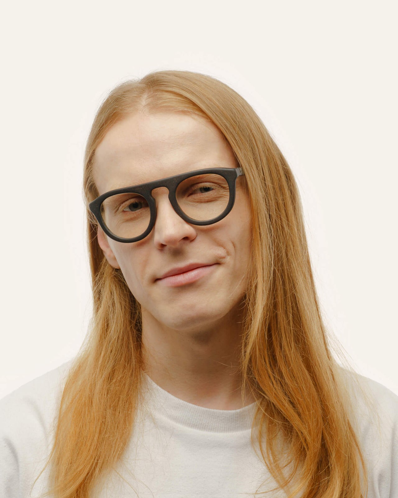 Load image into Gallery viewer, Man with long blond hair wearing trendy eco-friendly black eyeglasses, showcasing their lightweight design.
