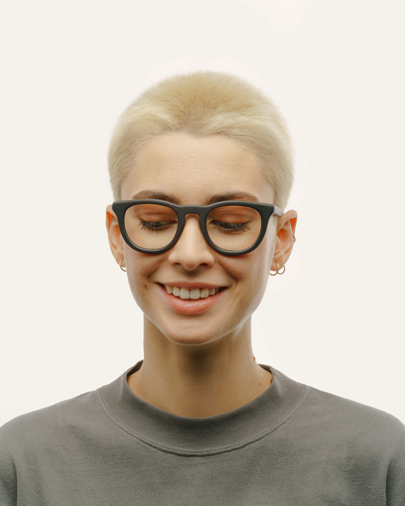 Woman smiling while wearing Anderson Black optical frames, showcasing their sleek design and coffee-based material