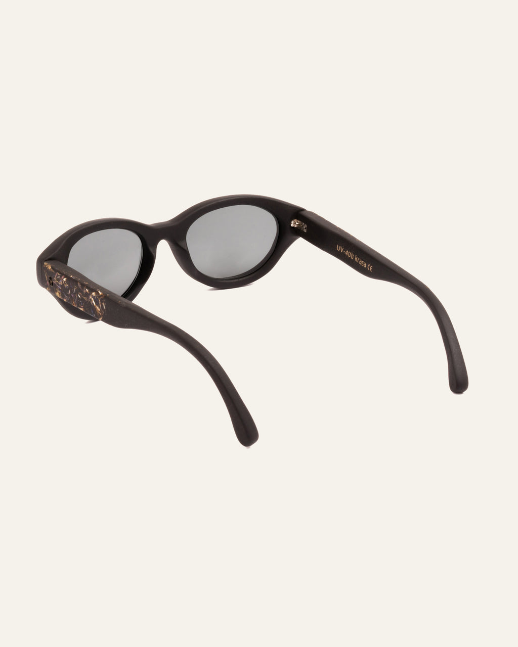 Angled view of eco-conscious sunglasses with cornflower petals and gray polarized lenses