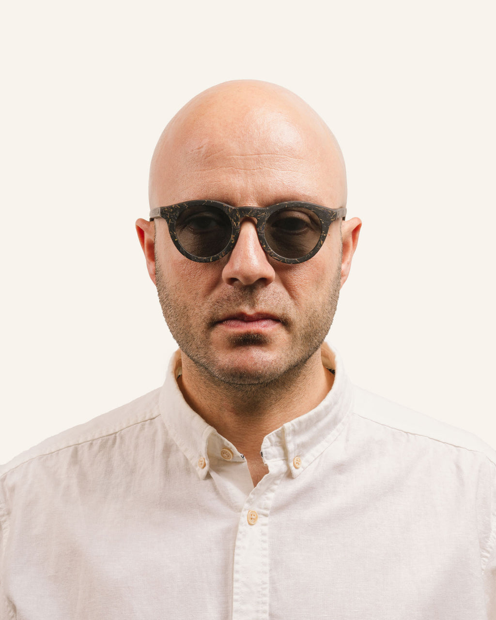 Man wearing Kole Krasa sunglasses, showcasing eco-friendly frames with cornflower petals and gray polarized lenses