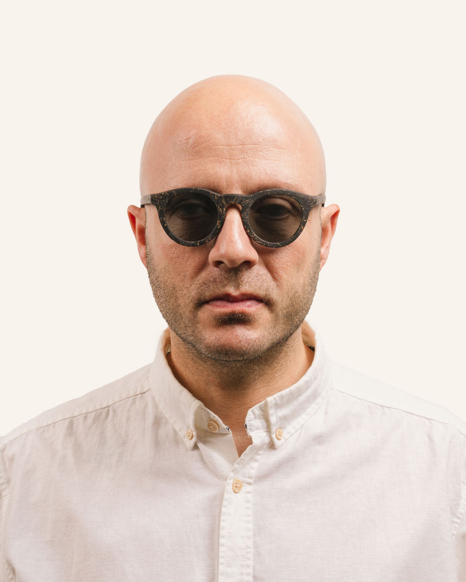 Man wearing Kole Krasa sunglasses, showcasing eco-friendly frames with cornflower petals and gray polarized lenses