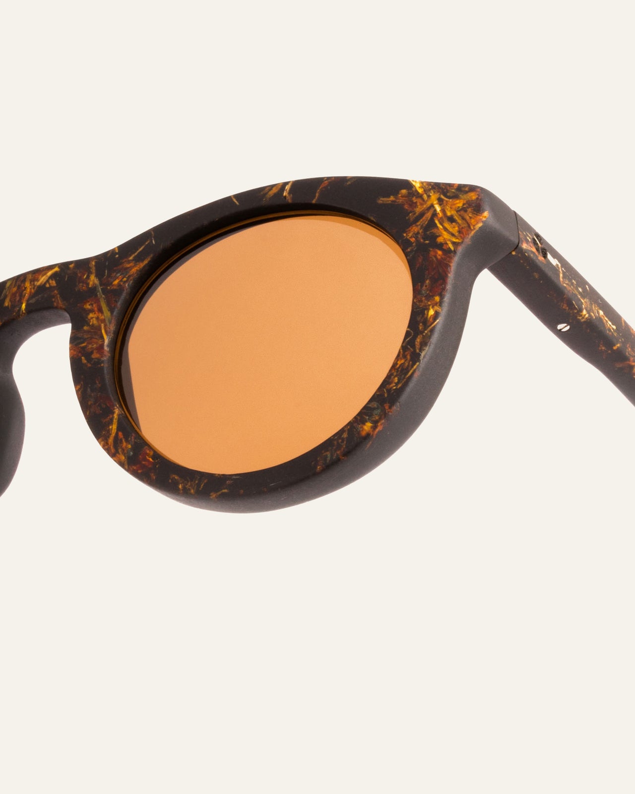 Load image into Gallery viewer, Close-up view of eco-friendly Kole Syla frames with marigold petals and brown lenses, showcasing sustainable craftsmanship
