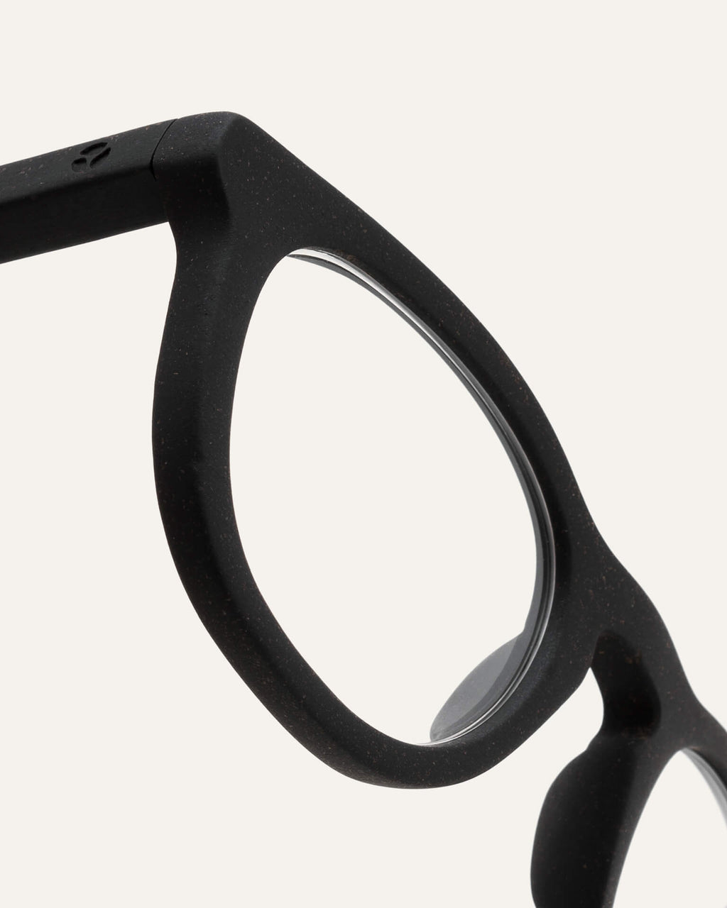 Close-up of trapezoidal prescription optical frames, showing their smooth black finish and eco-friendly coffee-based design.