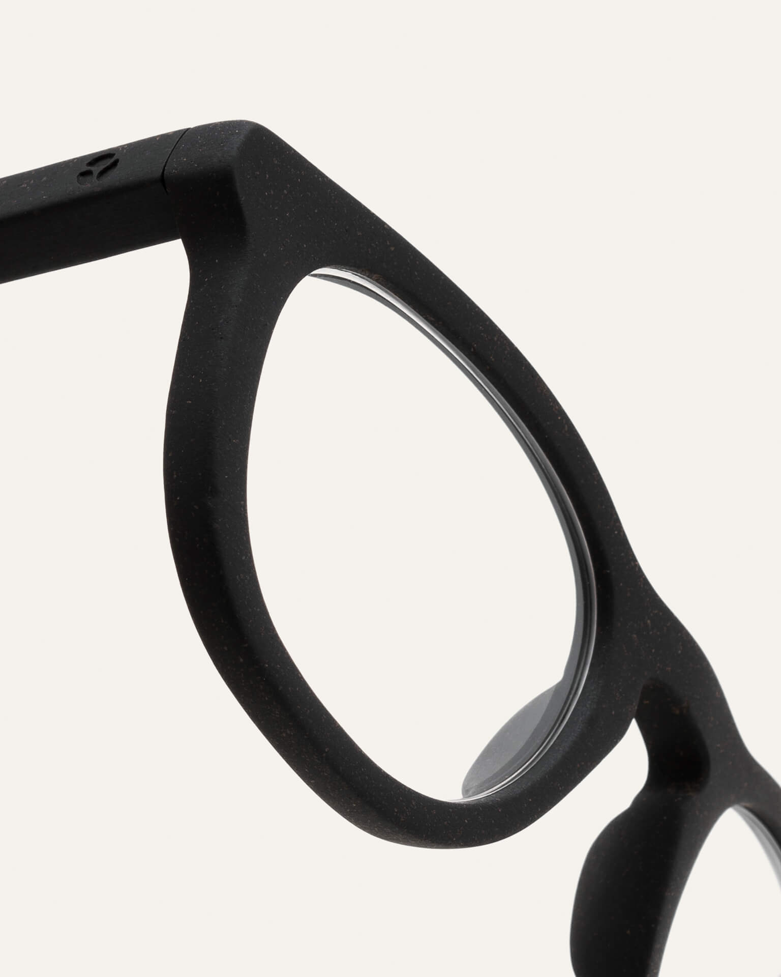 Close-up of trapezoidal prescription optical frames, showing their smooth black finish and eco-friendly coffee-based design.