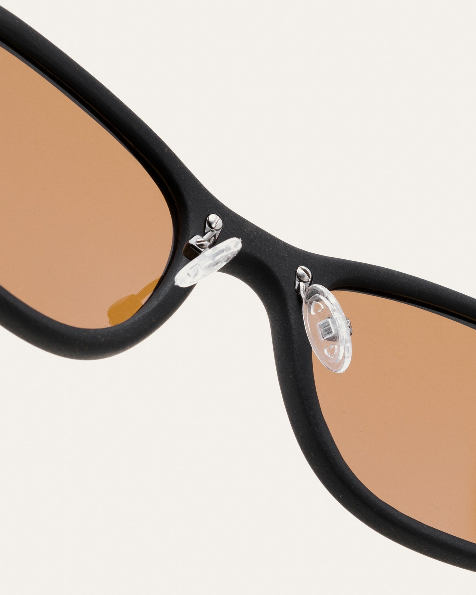 Close-up of sunglasses frame with flax straw texture, emphasizing biodegradable materials and sustainable style.