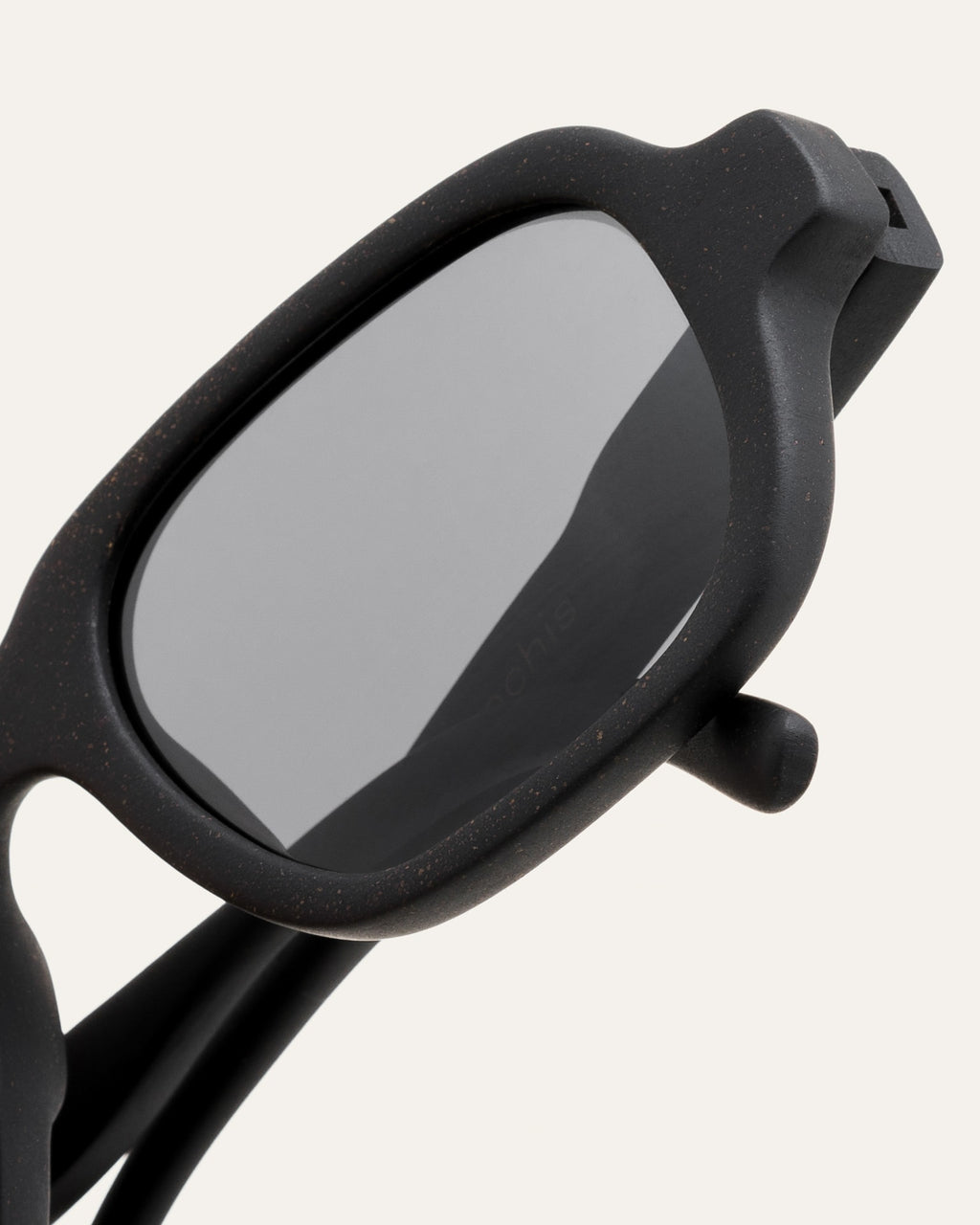 Close-up of Ochis Brade sunglasses, highlighting the refined details and smooth finish of the coffee-based frame