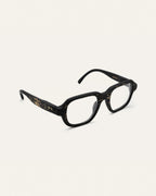 Angled view of black coffee-based frame with clear lenses.
