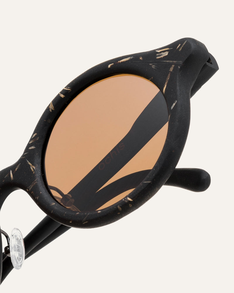 Black sunglasses with brown lenses and natural flax texture, combining eco-friendly materials with unique design.