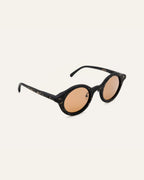 Side view of black sunglasses with brown lenses, featuring a lightweight frame and subtle flax accents