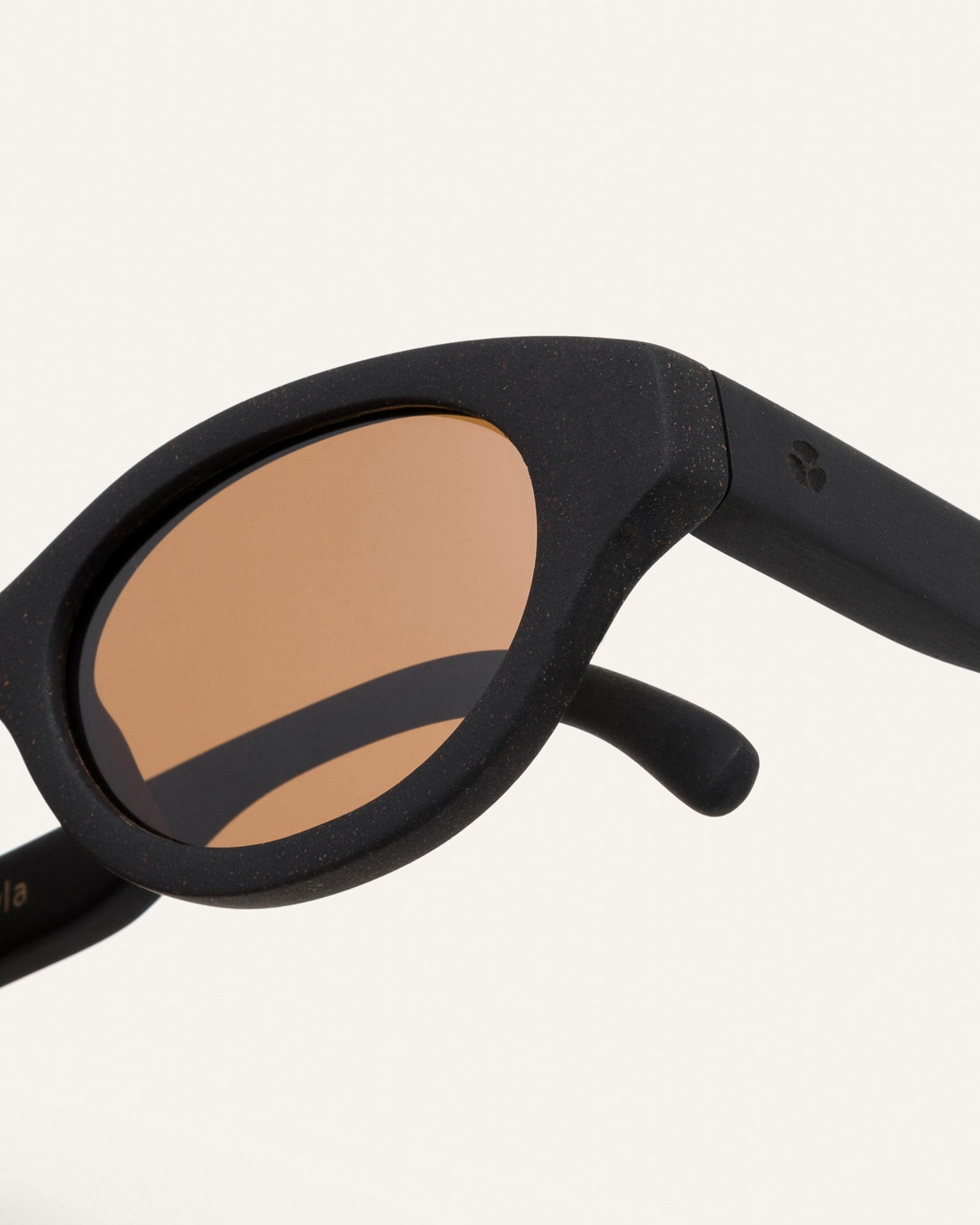 Close-up of Dayla sunglasses, featuring a sleek coffee-based black frame and rich brown polarized lenses for natural sun protection
