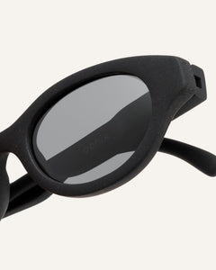 Close-up of Dayla eco-friendly sunglasses, highlighting the smooth coffee-based black frame and sleek lines