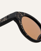 Close-up of eco-conscious coffee sunglasses, showcasing flax textures and rich brown lenses