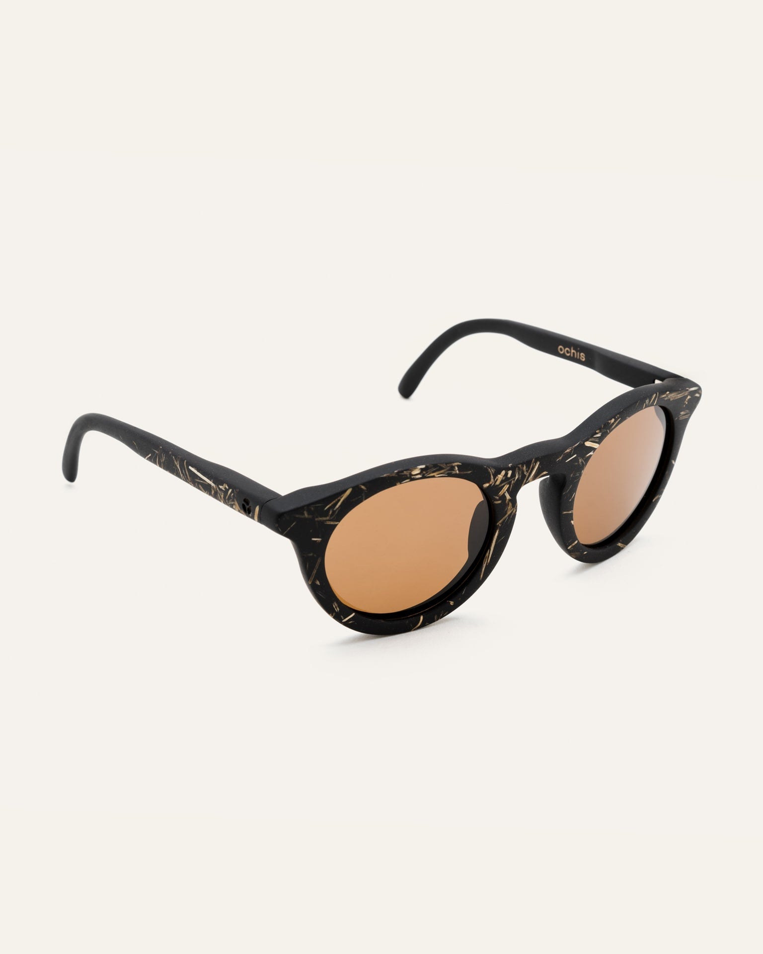 Angled view of black sunglasses with brown lenses, highlighting the natural flax accents on the handcrafted frames